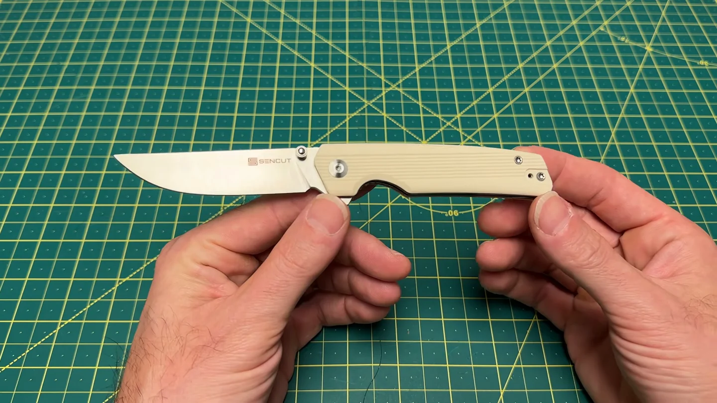 Open ivory G10 Sencut Stria held horizontally in Wayne’s hands